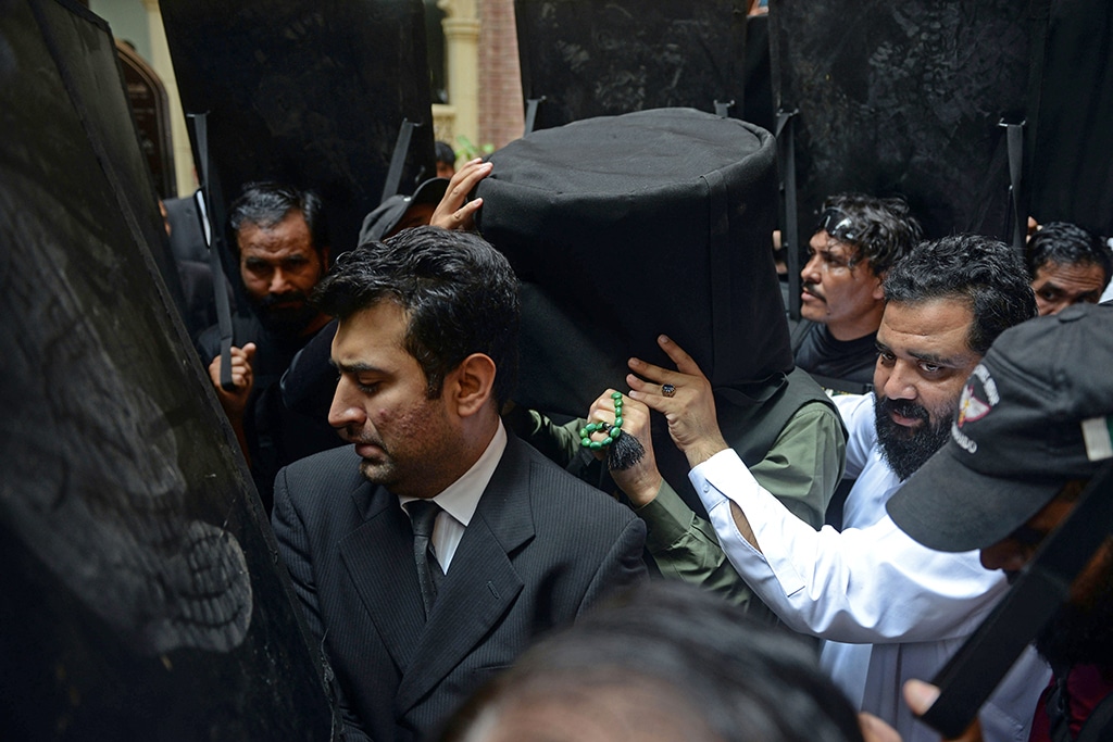LAHORE: Security personnel with ballistic shields escort former Pakistan's prime minister Imran Khan (C) to the High Court in Lahore. – AFP