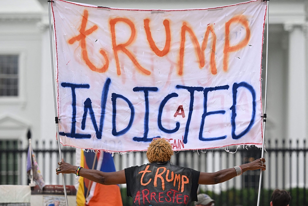 WASHINGTON: A woman celebrating the indictment of former US president Donald Trump holds a banner in front of the White House on June 9, 2023. – AFP