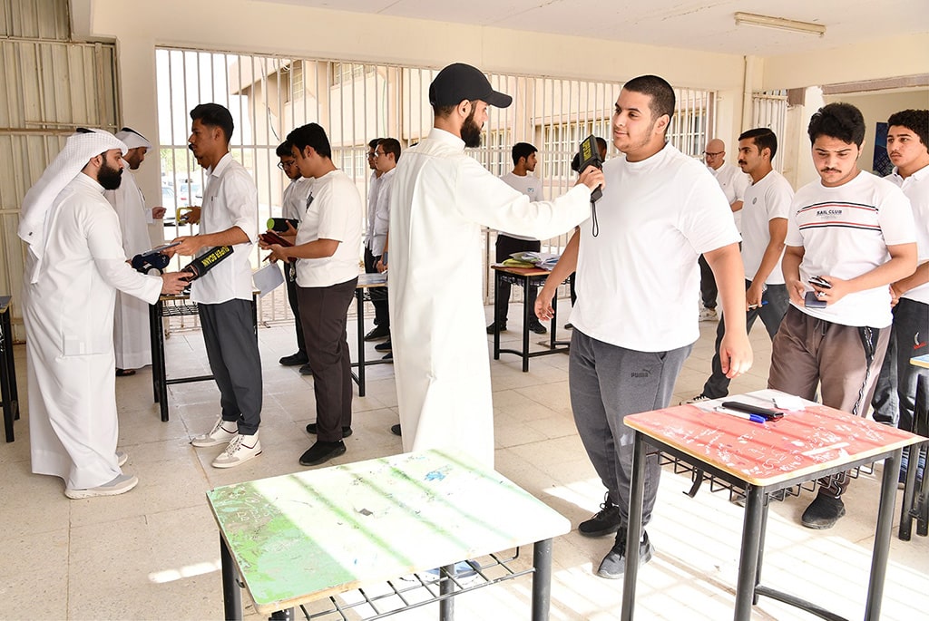 Students line up for a security check before entering the exam hall.
