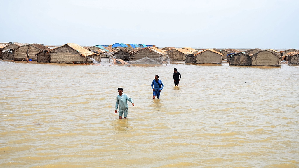 SUJAWAL, Pakistan: Cyclone affected people wade through water as Cyclone Biparjoy rises sea levels in a coastal area in Sindh province on June 15, 2023. – AFP
