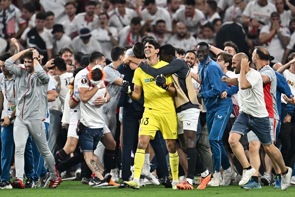 BUDAPEST: Sevilla's players including Moroccan goalkeeper Yassine Bounou (C) and some fans celebrate after winning the penalty shootout of the UEFA Europa League final football match between Sevilla FC and AS Roma at the Puskas Arena in Budapest, Hungary on May 31, 2023. - AFP
