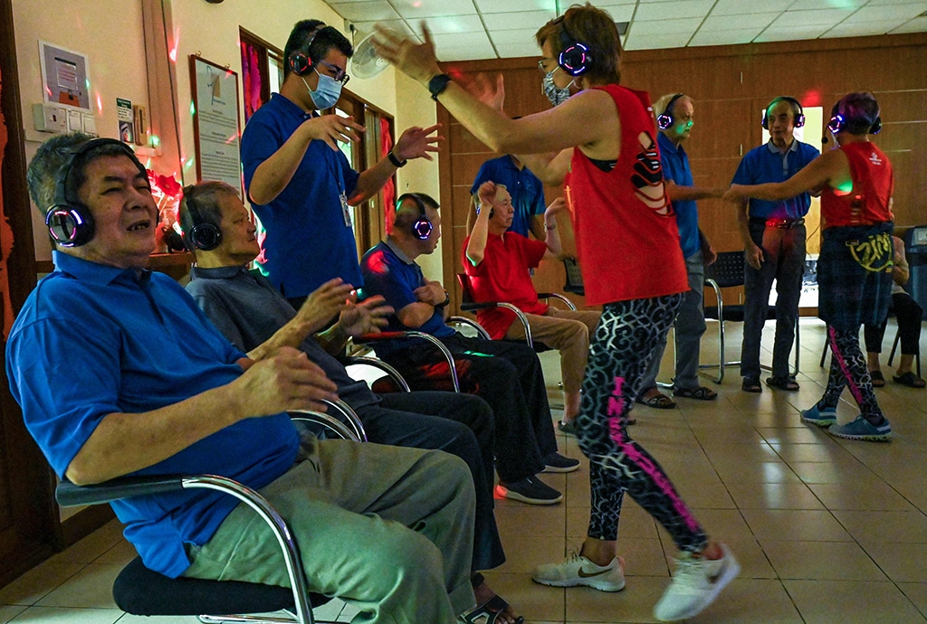 Residents with dementia participating in a silent disco at Apex Harmony Lodge in Singapore.