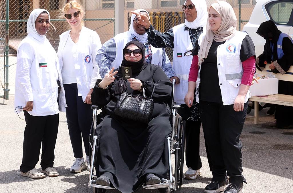 KUWAIT: Kuwait Red Crescent Society (KRCS) volunteers help an elderly woman get to the polling station. -- Photos by Yasser Al-Zayyat