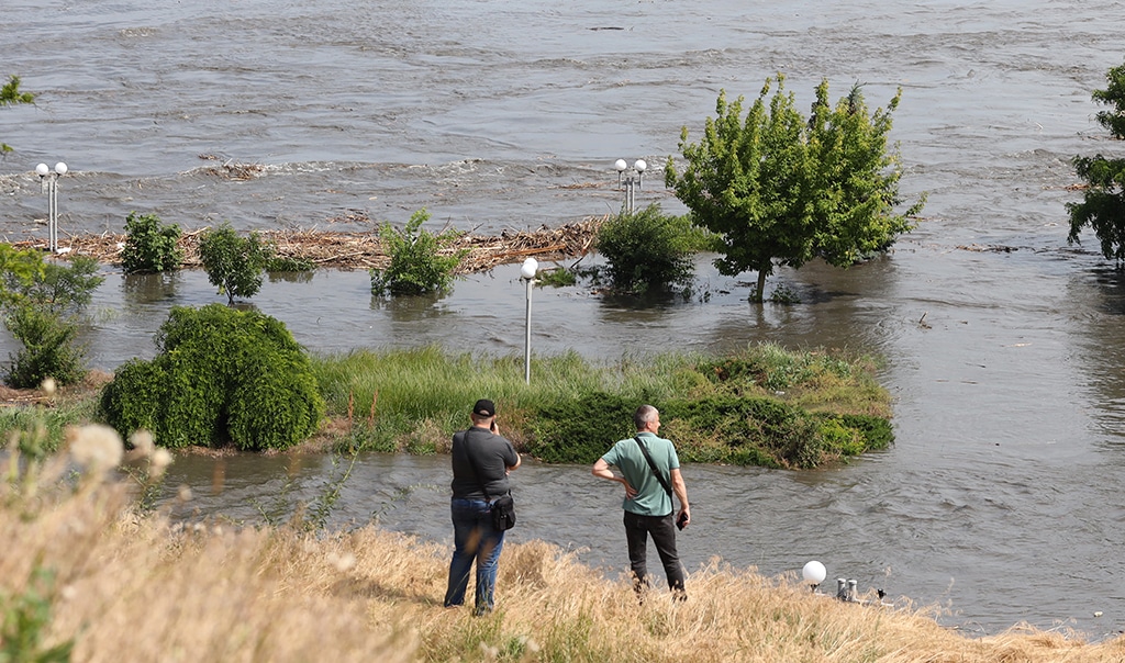 KHERSON: Local residents look at a partially flooded area of Kherson on June 6, 2023, following damage sustained at Kakhovka HPP dam.—AFP