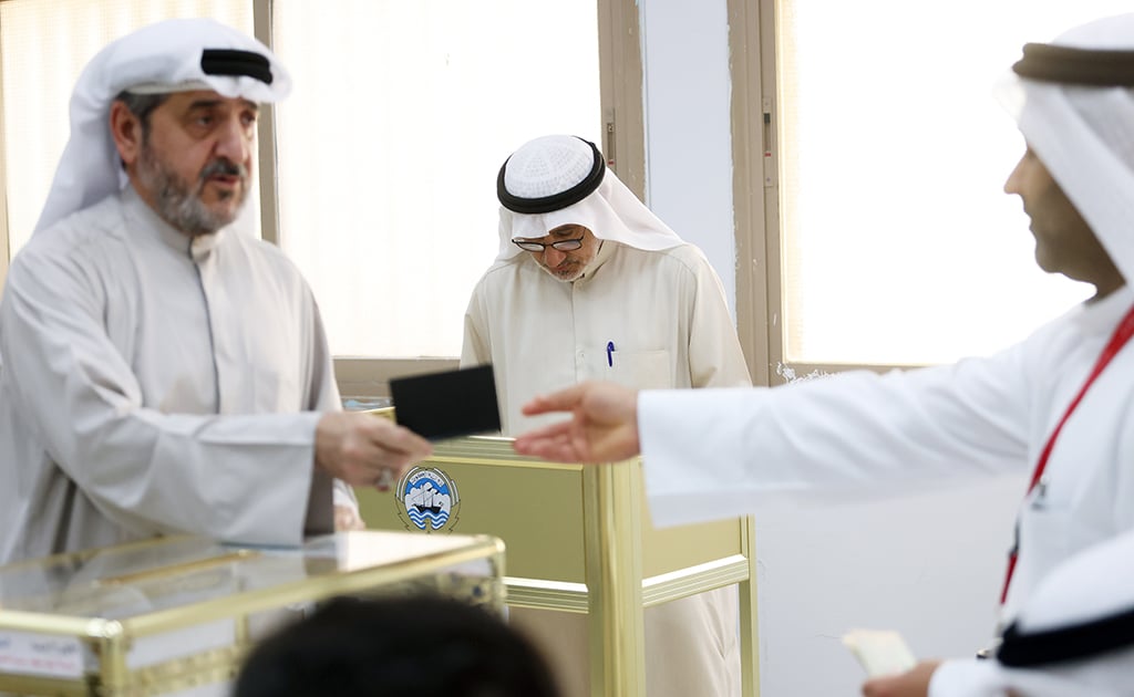 Kuwaiti men cast their votes during parliamentary elections in Kuwait City on June 6, 2023.