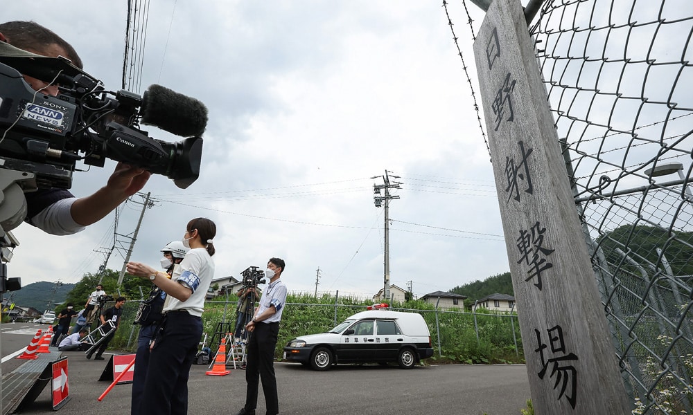 Members of the media (L) gather at the entrance to the Hino basic firing range in the city of Gifu, Gifu prefecture, on June 14, 2023, where a shooting incident occurred with soldiers from Japan's Ground Self-Defense Force (SDF) at the training range.