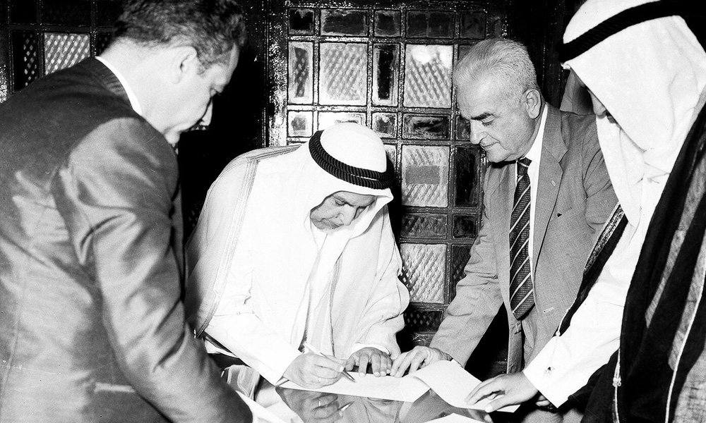Late Sheikh Abdullah Al-Salem signing the declaration of independence with the British Government representative in Arabian Gulf