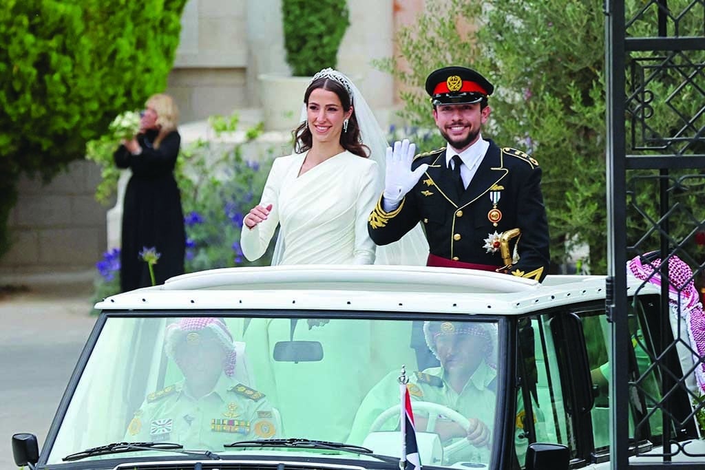 AMMAN: Jordan's Crown Prince Hussein and his wife Rajwa AlSeif wave as they leave the Zahran Palace in Amman on June 1, 2023 following their royal wedding ceremony. The ceremony was held in the mid-century Zahran Palace-the site of other key royal weddings including that of King Abdullah II to Queen Rania as well as that of his father, the late King Hussein bin Talal. - AFP