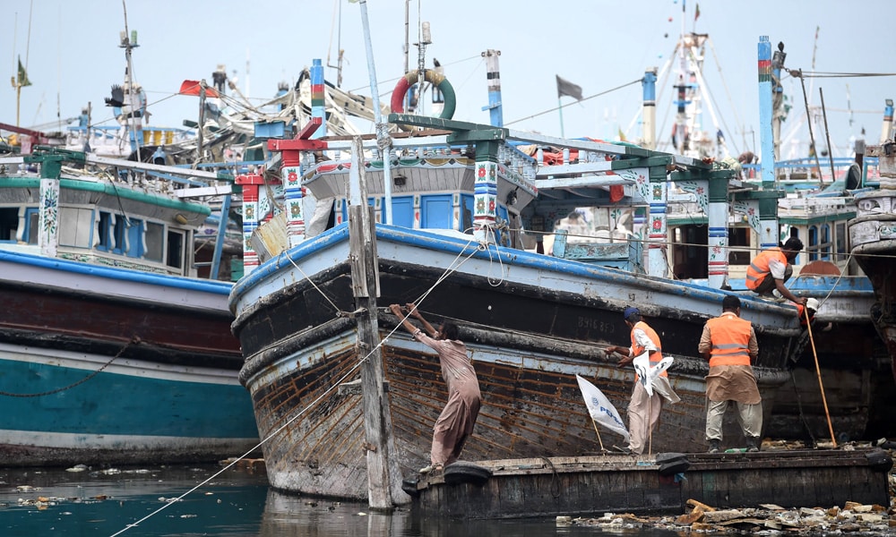 Fishermen moor their boat at Karachi port as a part of precautionary measures before the due onset of cyclone, in Karachi on June 14, 2023.