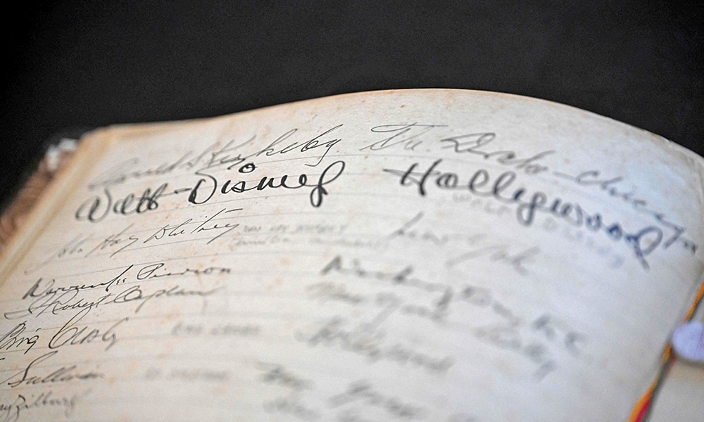 A hotel worker shows the signature of the late founder of the Disney company, Walt Disney (1901–1966), in the Golden Book of the Belmond Copacabana Palace Hotel.