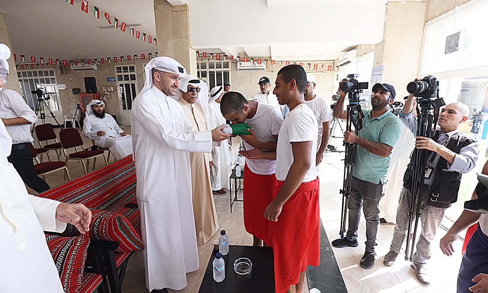 Deputy Director-General of Public Authority for Sport (PAS), Bashar Al-Salem delivers the flag of Kuwait to the young diver