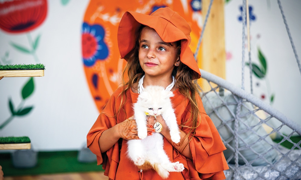A girl holds a feline at the newly inaugurated Cat Cafe in Gaza City.--AFP photos