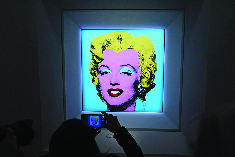 A guest takes a photo during Christie's announcement that they will offer Andy Warhol’s Shot Sage Blue Marilyn painting of Marilyn Monroe at Christie’s in New York City.—AFP