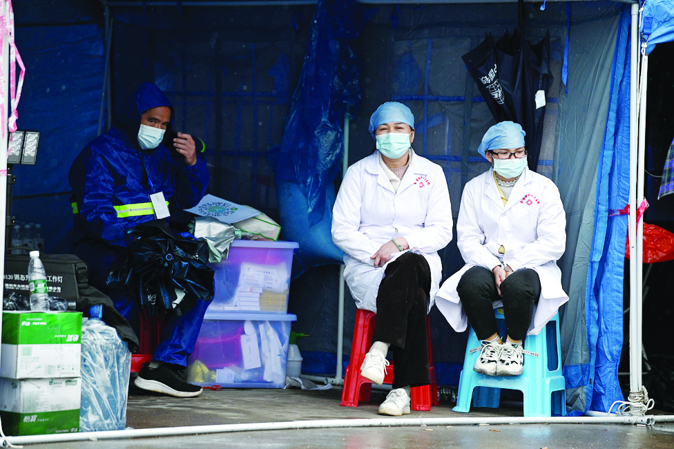 WUZHOU, China: Volunteers look on near the entrance to Lv village which leads to the crash site of China Eastern flight MU5375 in Wuzhou in southwestern China's Guangxi province on March 23, 2022.-AFP