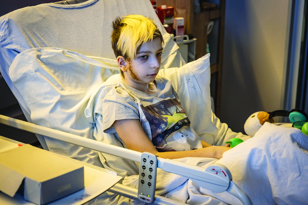 KYIV, Ukraine: Volodymyr, 13-years-old, sits in a hospital bed after being injured, in Kyiv. His family's car was caught in gunfire between Russian and Ukranian troops in Kyiv, on February 26. His father was killed and his mother was injured. - AFP