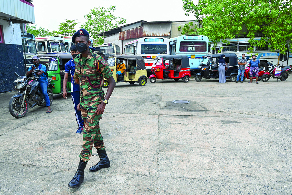 COLOMBO: A soldier guards a fuel station in Colombo on March 22, 2022. Sri Lanka ordered troops to petrol stations on March 22 as sporadic protests erupted among the thousands of motorists queuing up daily for scarce fuel. - AFP
