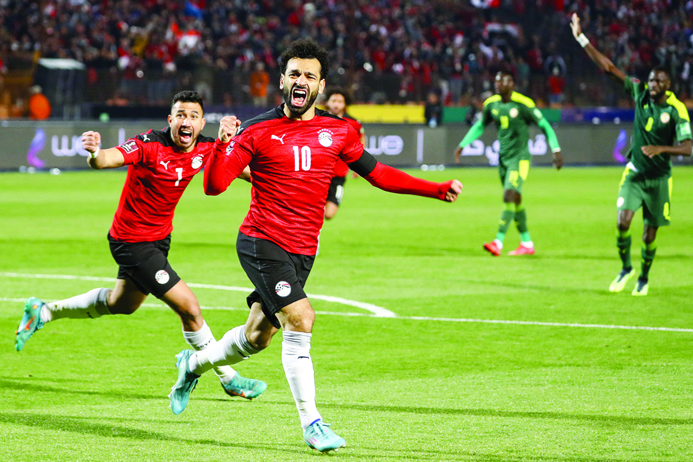 CAIRO:  Egypt's forward Mohamed Salah (right) and Egypt's midfielder Mahmoud 'Trezeguet' Hassan (left) celebrate after a goal during the 2022 Qatar World Cup African Qualifiers football match between Egypt and Senegal on March 25, 2022. - AFP