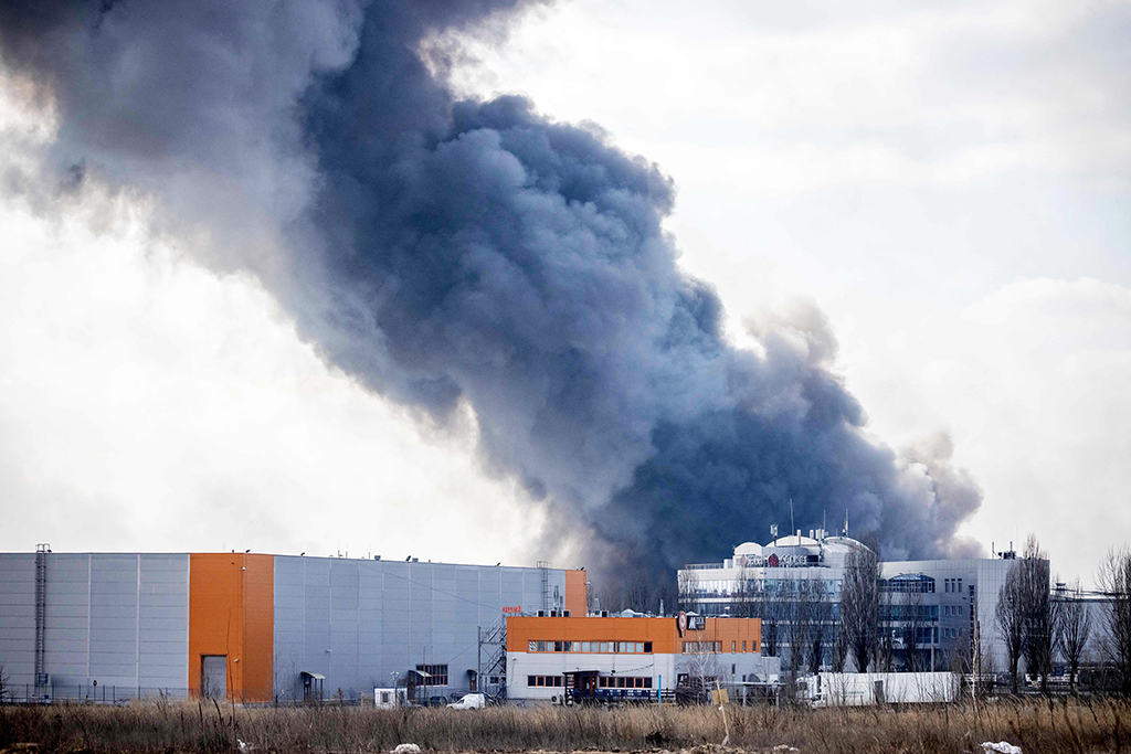KYIV: This photograph taken on March 24, 2022 shows smoke rising from a burning warehouse hit by a Russian shell in the suburbs of Kyiv. - AFP