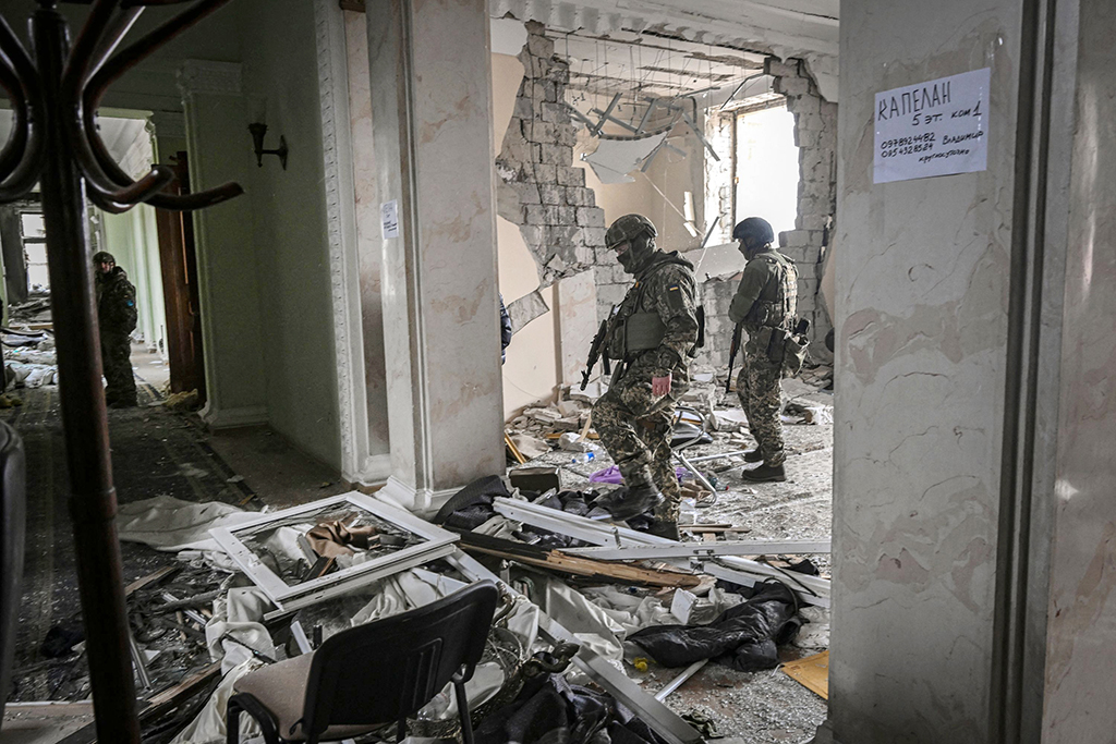 KHARKIV, Ukraine: Ukrainian servicemen walk inside the destroyed regional headquarters of Kharkiv on March 27, 2022. – AFP