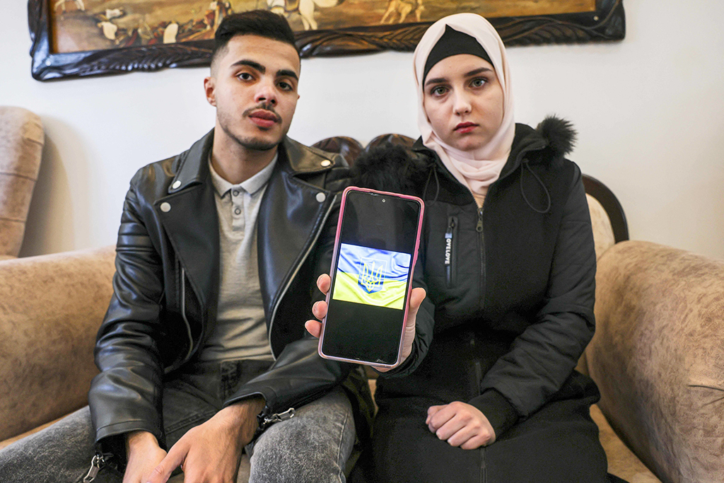 GAZA: Ukrainian Viktoria Saidam, accompanied by her Palestinian husband Ibrahim Saidam, shows an image on her mobile phone at their family home in the refugee camp of Bureij on March 22, 2022. - AFP