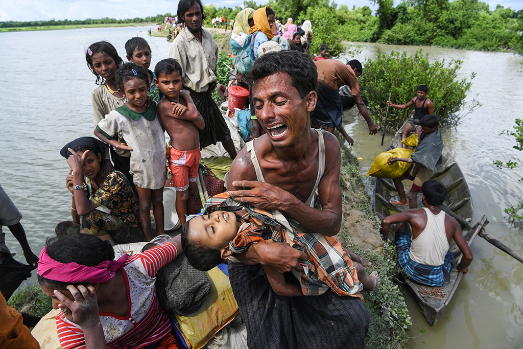 In this file photo taken on Oct 9, 2017, a Rohingya refugee reacts while holding his deceased son after crossing the Naf river from Myanmar into Bangladesh in Whaikhyang. – AFP