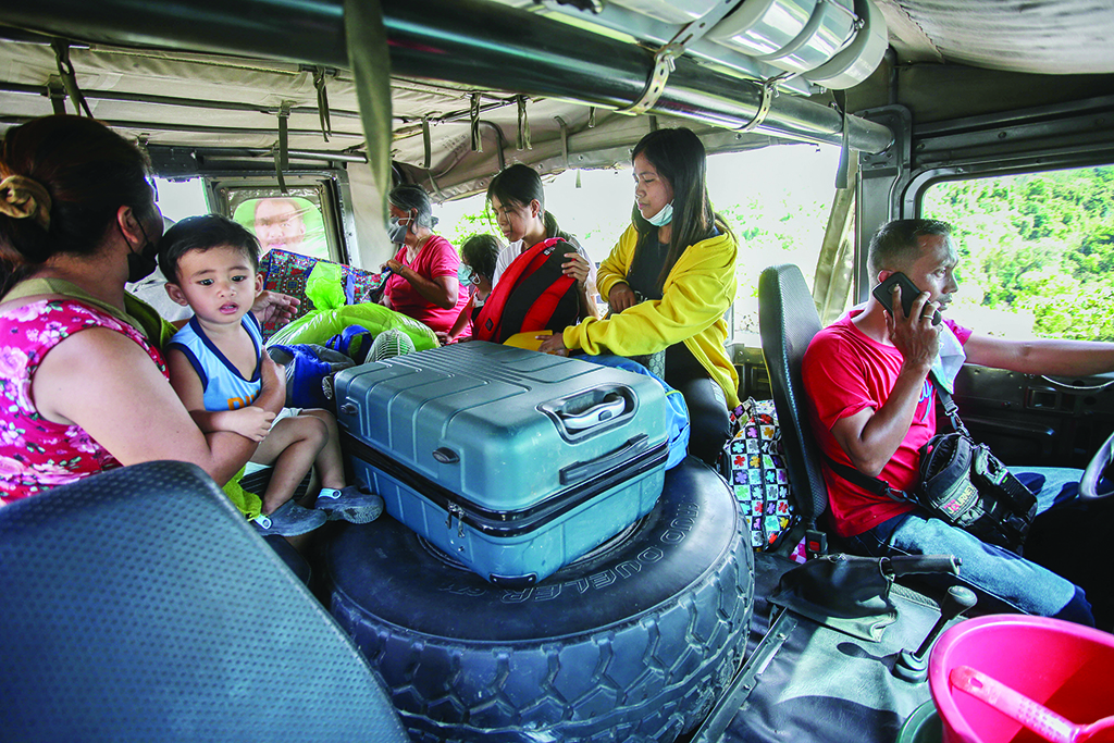 LAUREL, Philippines: Residents living near Taal volcano ride a vehicle as they evacuate to a public school in Laurel, Batangas, on March 26, 2022, after an eruption earlier in the morning sent ash and steam hundreds of metres into the sky. - AFP