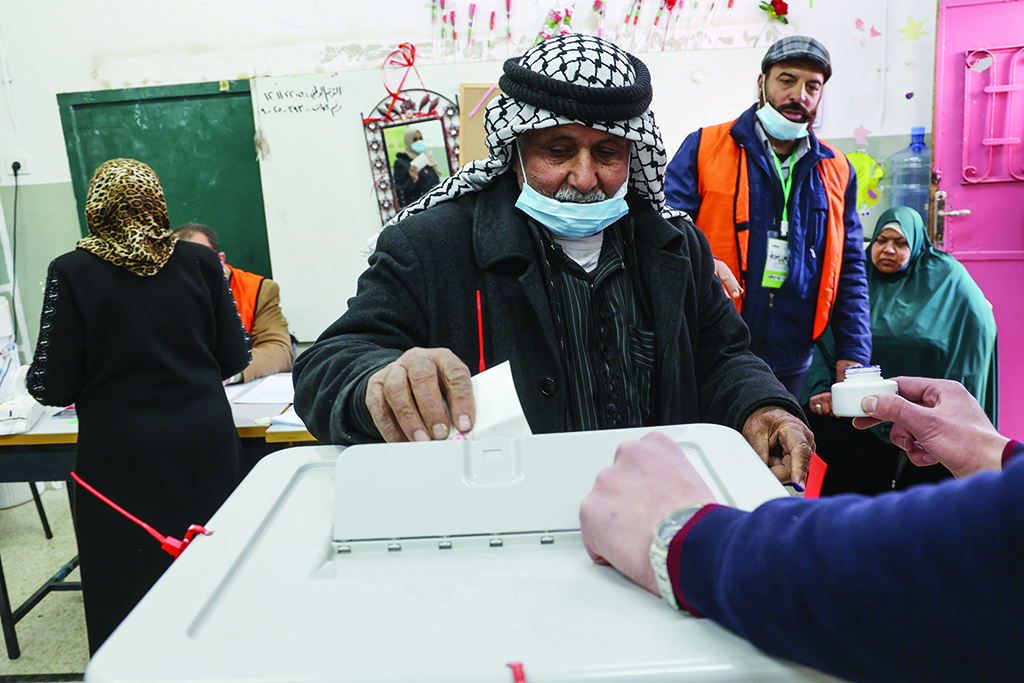 BEIT FURIK,Palestinian Territories: An elderly Palestinian man casts his ballot as he votes in the local elections in Beit Furik, east of the West Bank city of Nablus, on March 26, 2022. - AFP