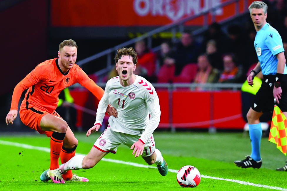 AMSTERDAM: Netherlands' midfielder Teun Koopmeiners (left) fights for the ball against Denmark's forward Andreas Skov Olsen during the friendly international football match between Netherlands and Denmark on March 26, 2022. - AFP